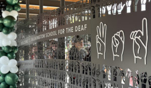 An art gate with laser-cut messaging, including the words "Welcome to Washington School for the Deaf" and phrases spelled out in the ASL finger-spelling alphabet