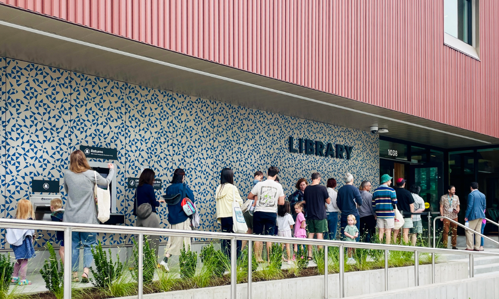 A line of people waiting to enter Belmont Library on opening day
