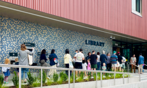 A line of children and adults queue up outside Belmont Library on opening day.