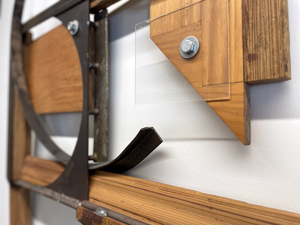 A detail image of a wall-mounted sculpture made from steel, wood and acrylic