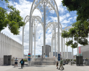 The newly opened entrance to the PacSci courtyard with ticket gates removed, framed by the historic arches. Wayfinding banners with maps and directions are mounted at the courtyard stairs.